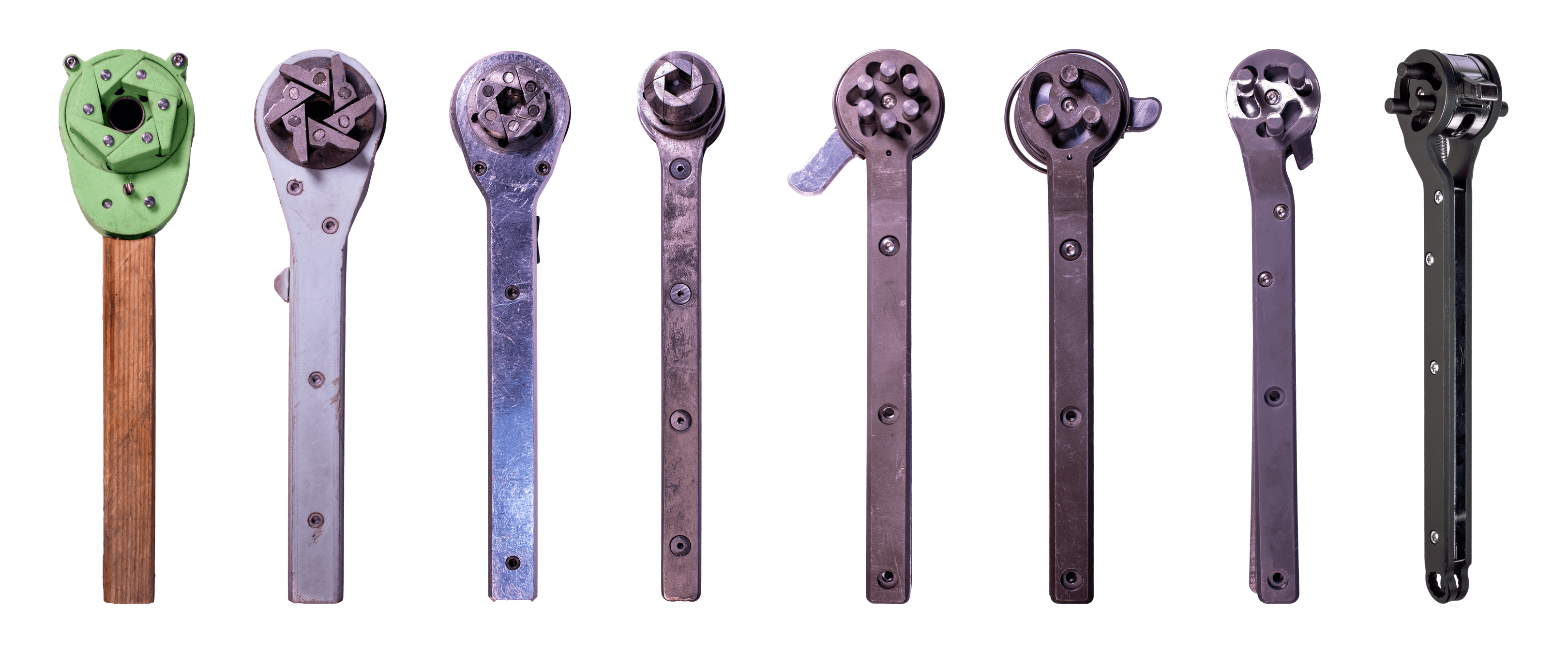 Eight Trevor's Wrench prototypes showing the design evolving from an early green model to the latest black working design